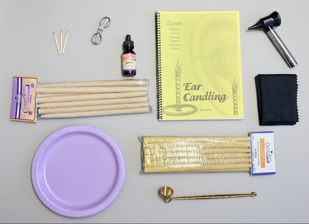Ear candling kit with candles, tools, and a notebook on a red surface